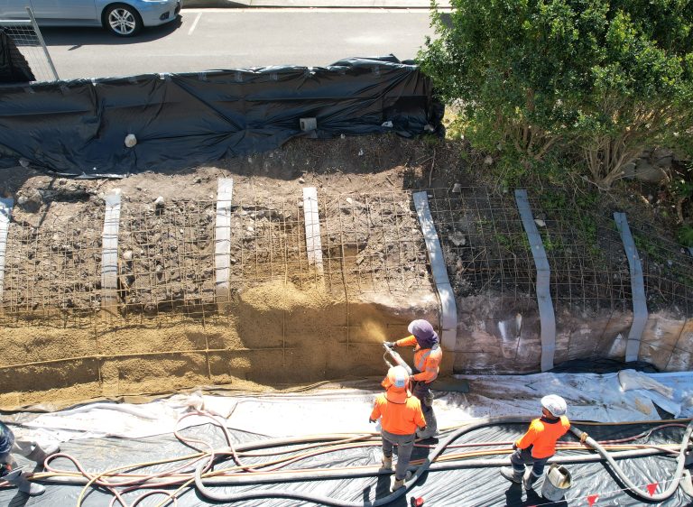 Image shows Convil Group shotcreting an embankment wall with concrete